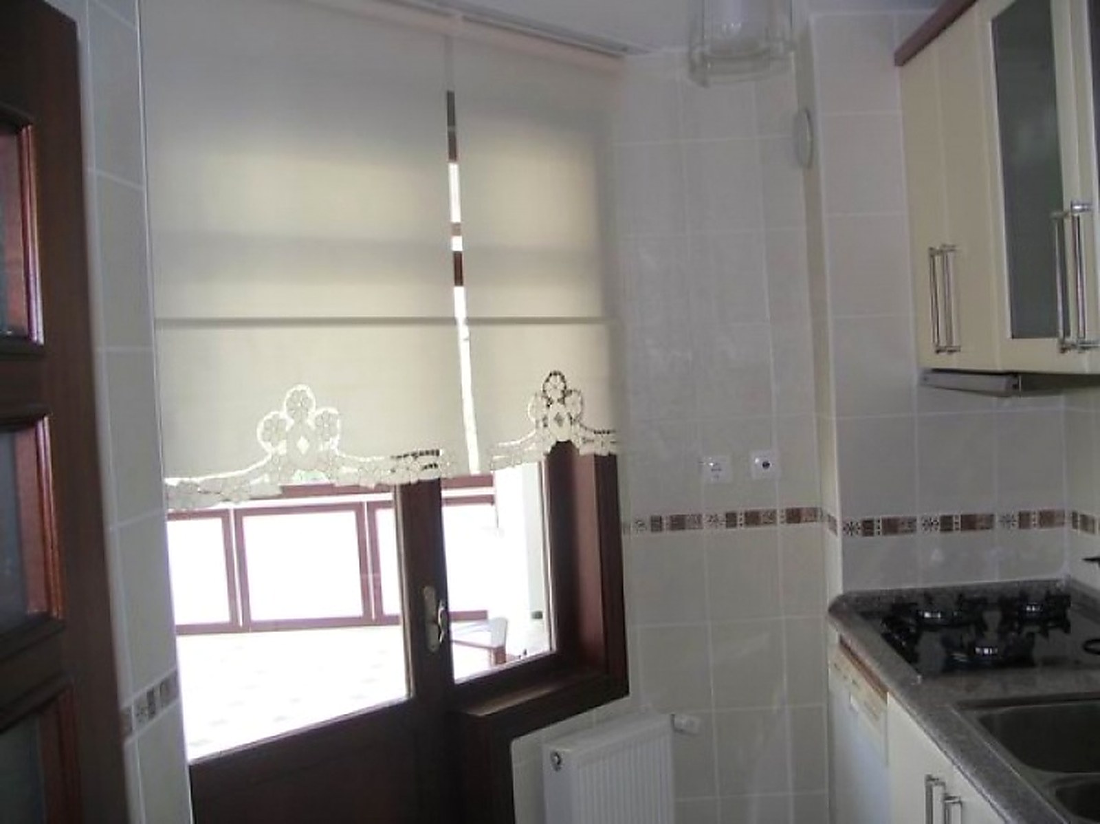 Ankara Residential Kitchen & Balcony Door Installation — Stain-Resistant Cream Roller Blind Accented with French Guipure Lace Scalloped Hem